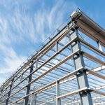 steel frame workshop is under construction against a blue sky