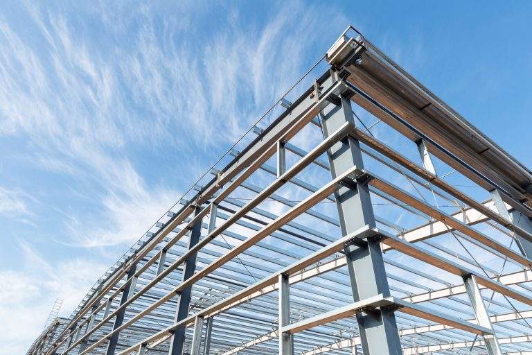 steel frame workshop is under construction against a blue sky