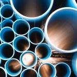 Blue plastic pipes used in construction site.Blue PVC water pipe in storage.Packaged blue plastic water pipes at warehouse.