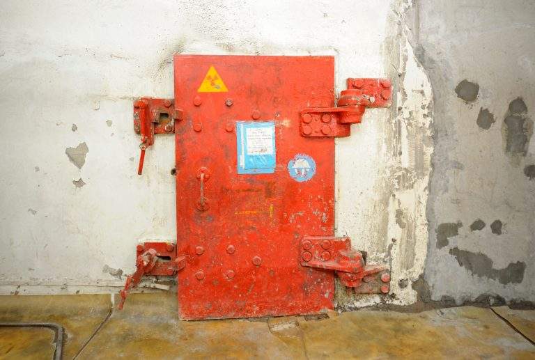 Metal protective door to the block with contaminated radioactive equipment placed after disaster in 1986. April 20, 2018. Chernobyl Nuclear Power Plant, Ukraine