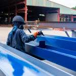 The painter is working to painting the steel structure with spra