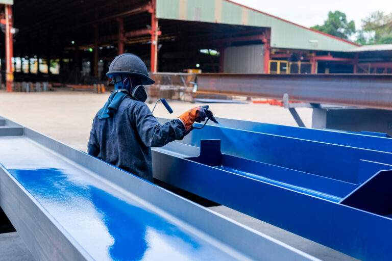 The painter is working to painting the steel structure with spra