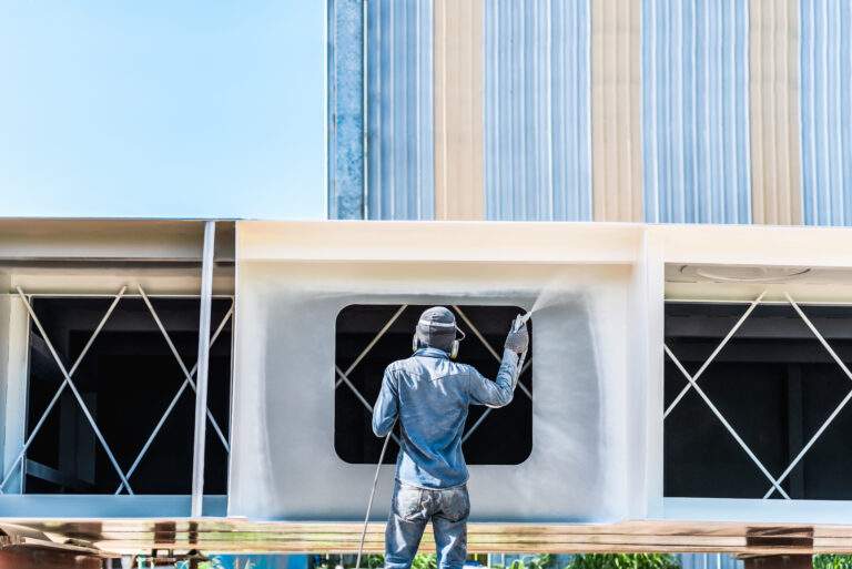Airless Spray Painting, Worker painting on steel wall surface by airless spray gun for protection rust and corrosion.